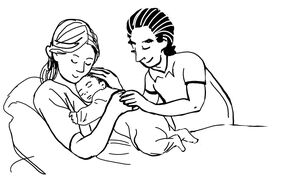 Eine junge Frau liegt in einem Bett. Sie hält ein Baby im Arm. Neben ihr ein junger Mann, der seine Hand auf diejenige der Frau legt, die das Baby hält.